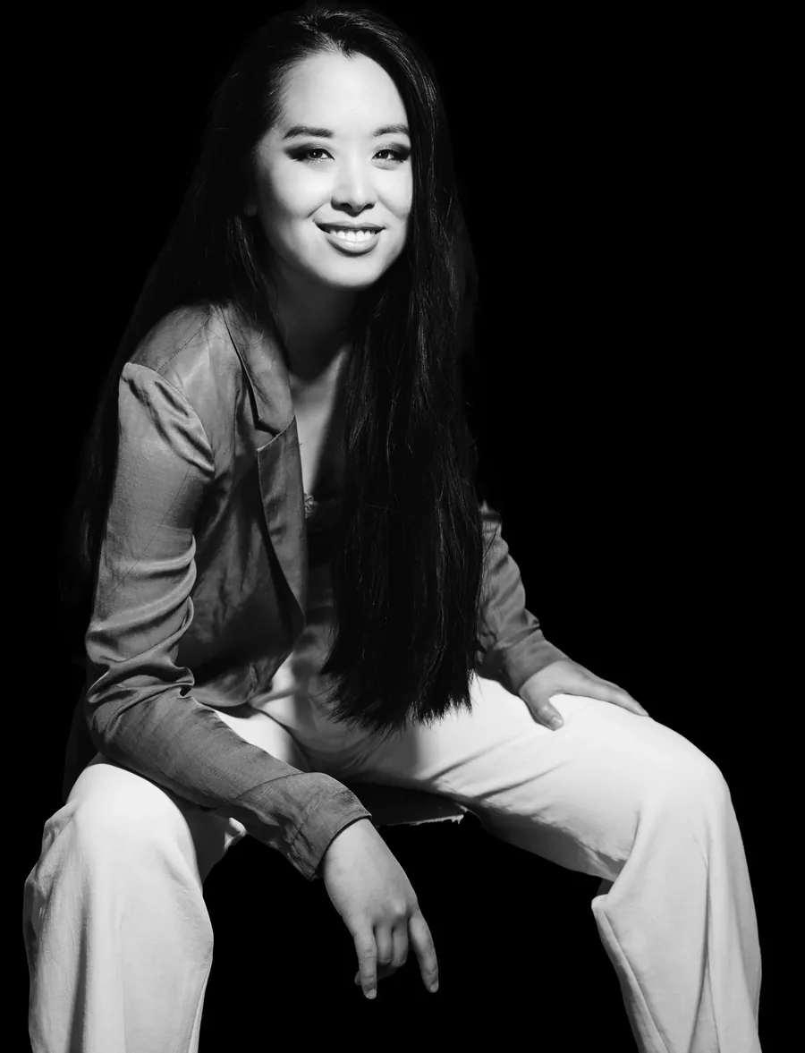 Portrait en noir et blanc de Fiona Wu, assise, souriante